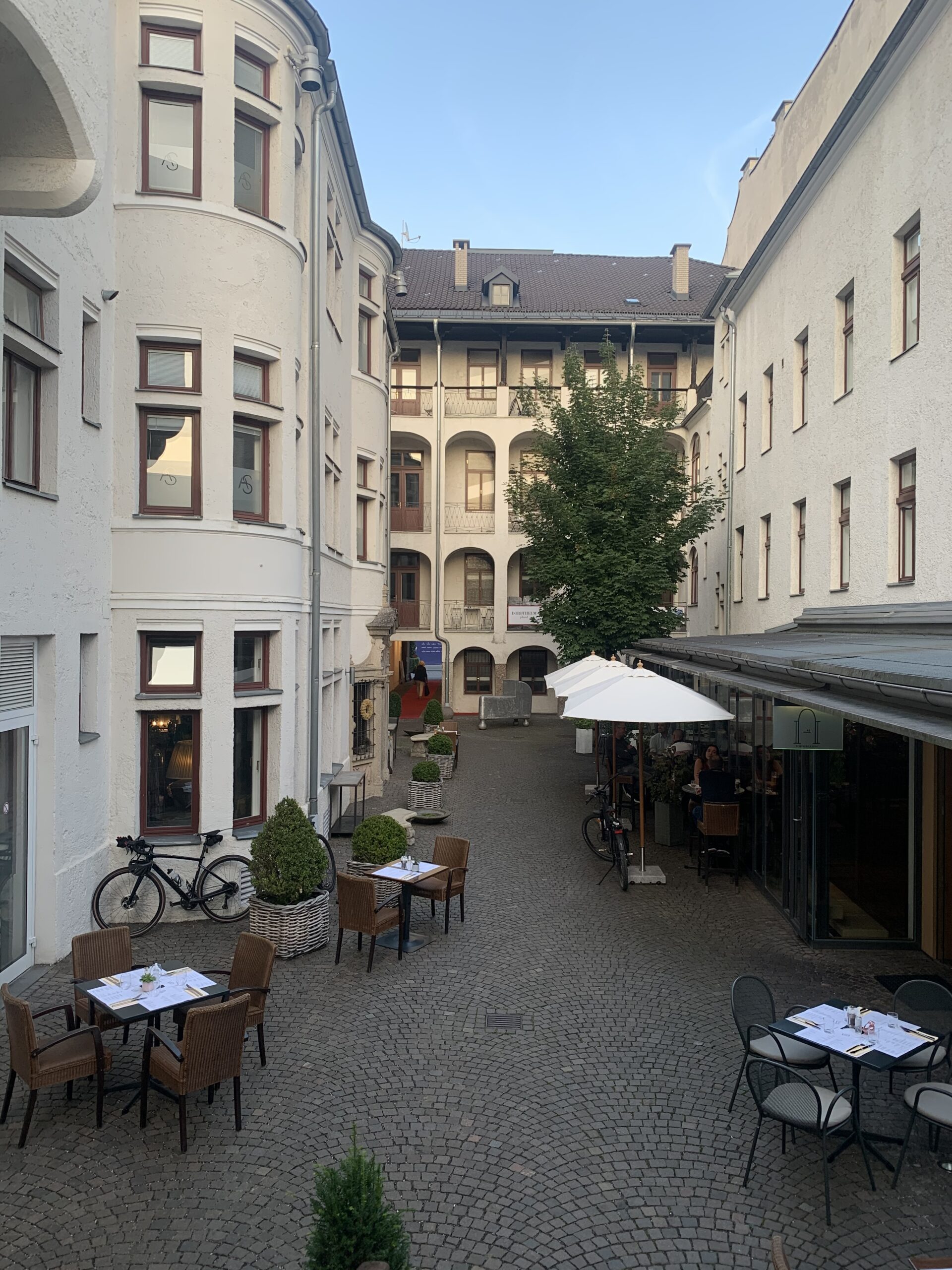 Innenhof mit Tischen und Schirmen am Abend