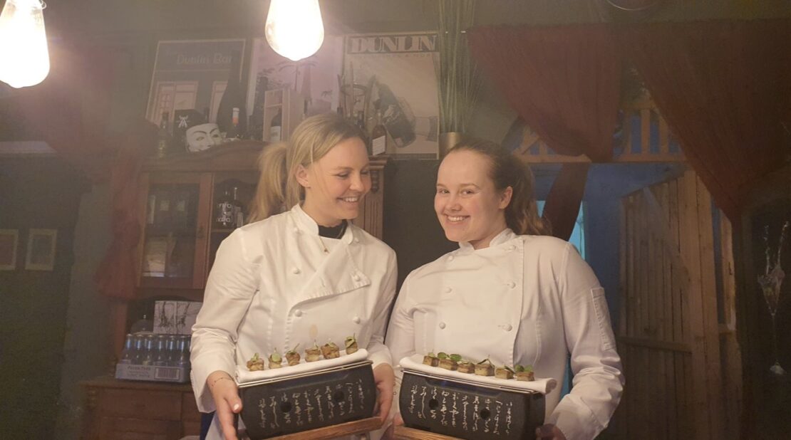 2 Mitarbeiterinnen lachend mit Amuse Bouche auf kleinem Konro-Grill