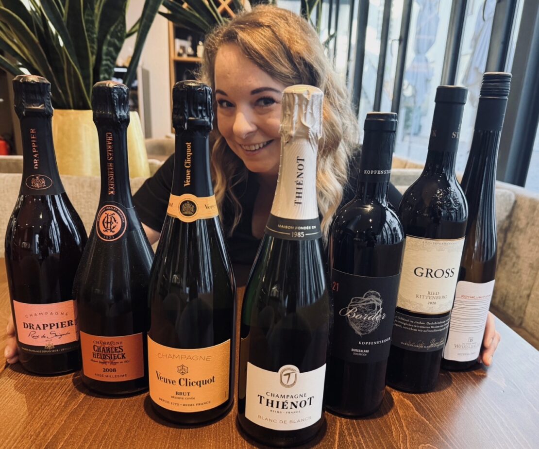 Chefin mit Flaschen von Wein und Champagner