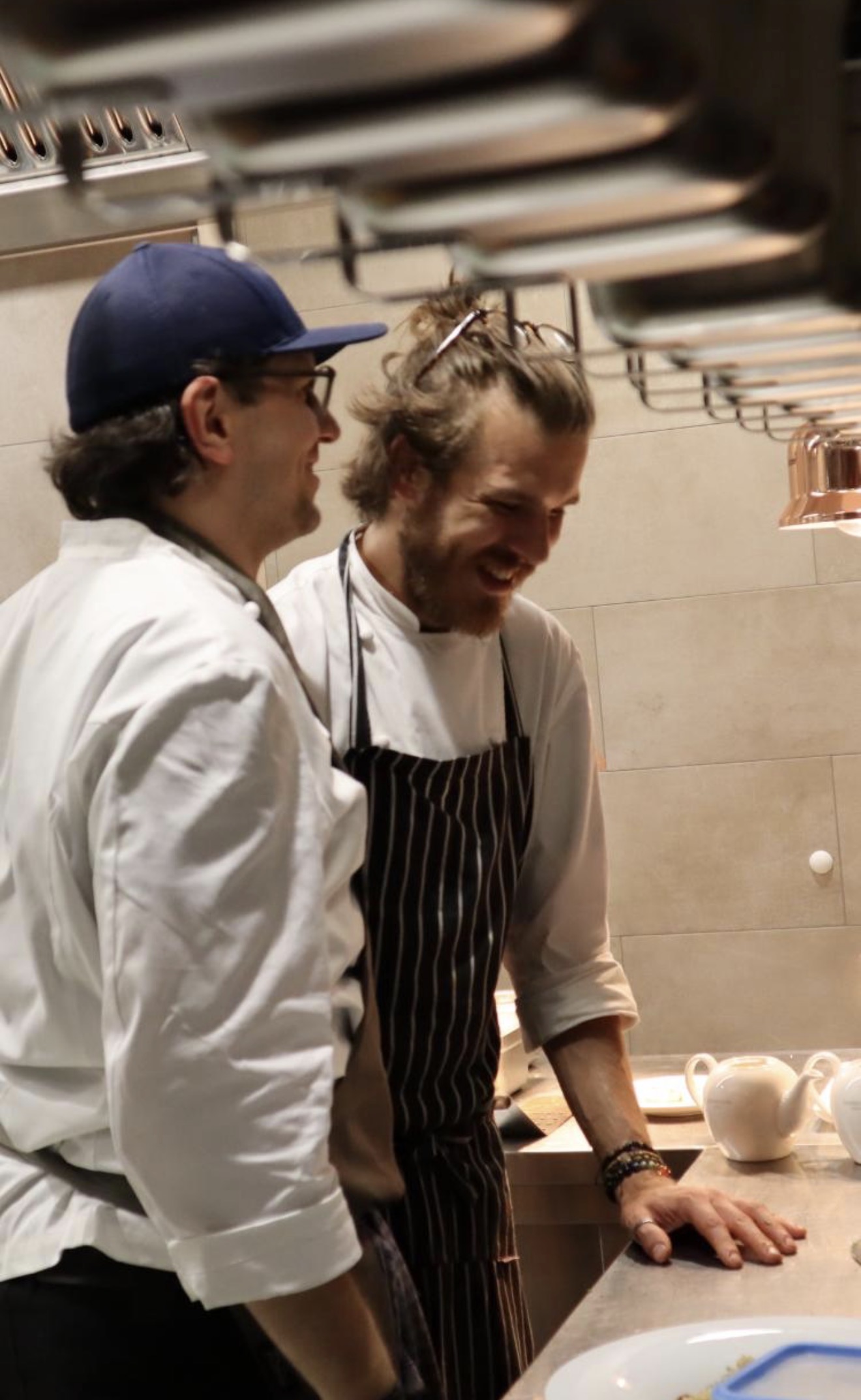 Chefkoch und Chef in der Kueche lachend