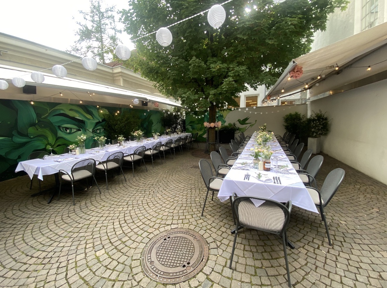 Two long tables in the garden under a tree