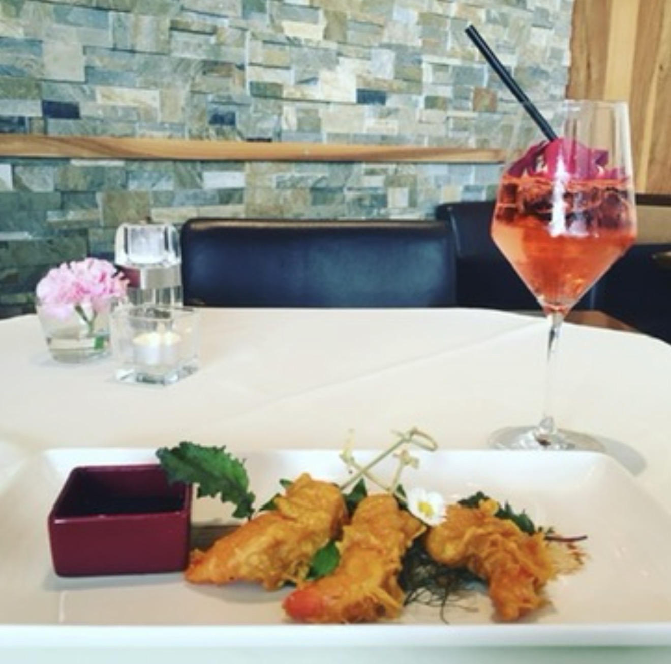 gebackene Shrimps und ein Aperitif auf einem gedeckten Tisch