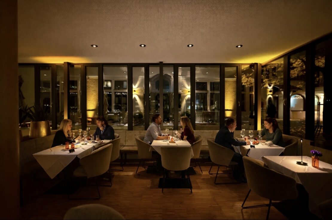 mehrere Gäste an einem Tisch sitzend und genießen den Abend