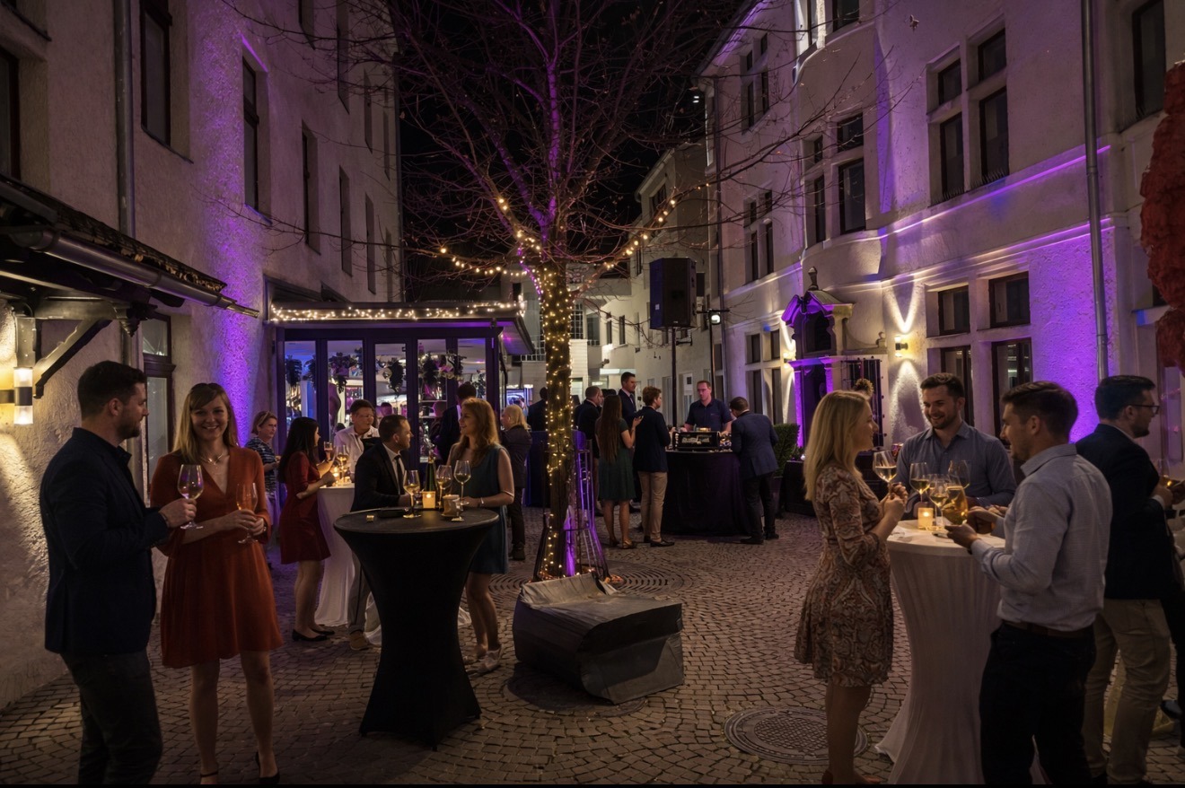 belebter Innenhof mit vielen Gästen, feinem Ambiente und DJ