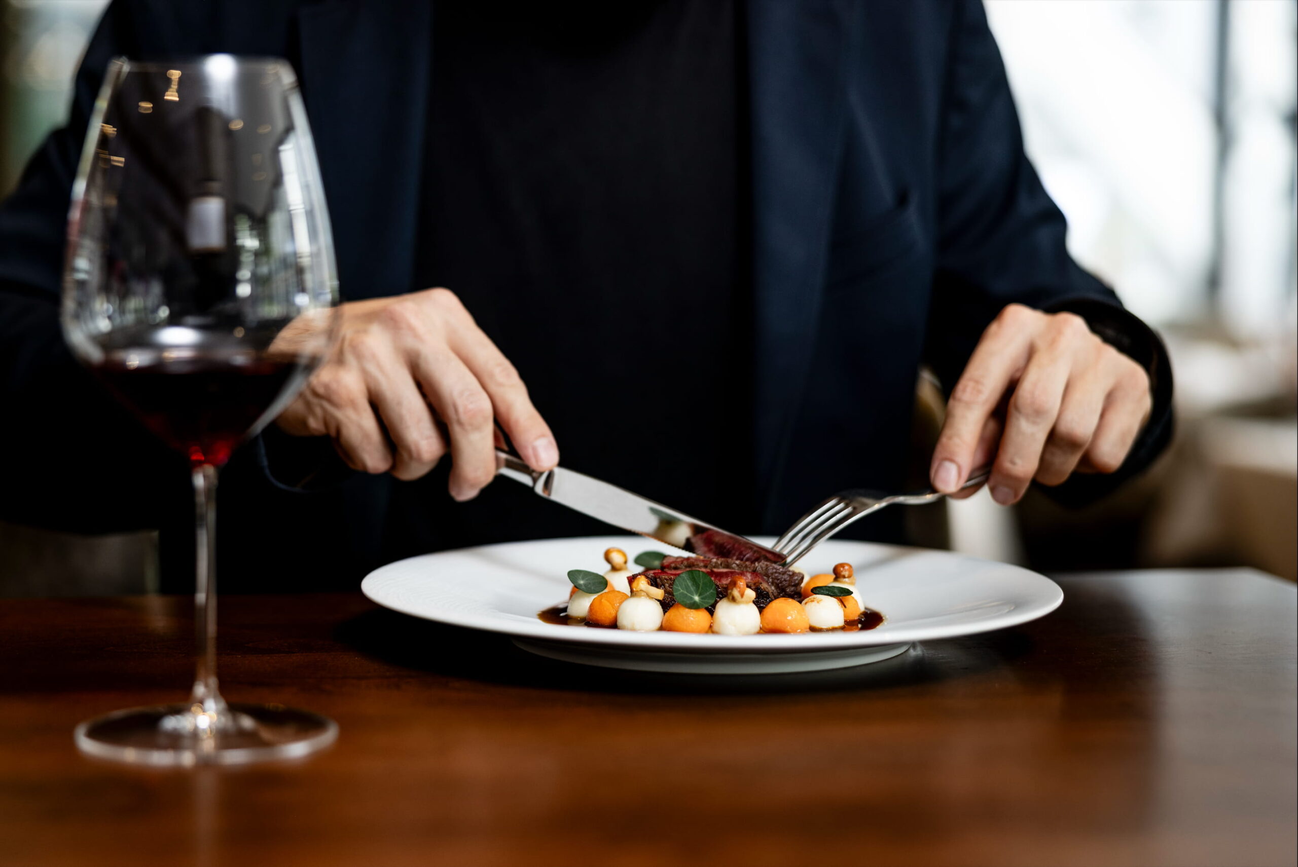 eine Hauptspeise mit Messer und Gabel und einem Glas Rotwein