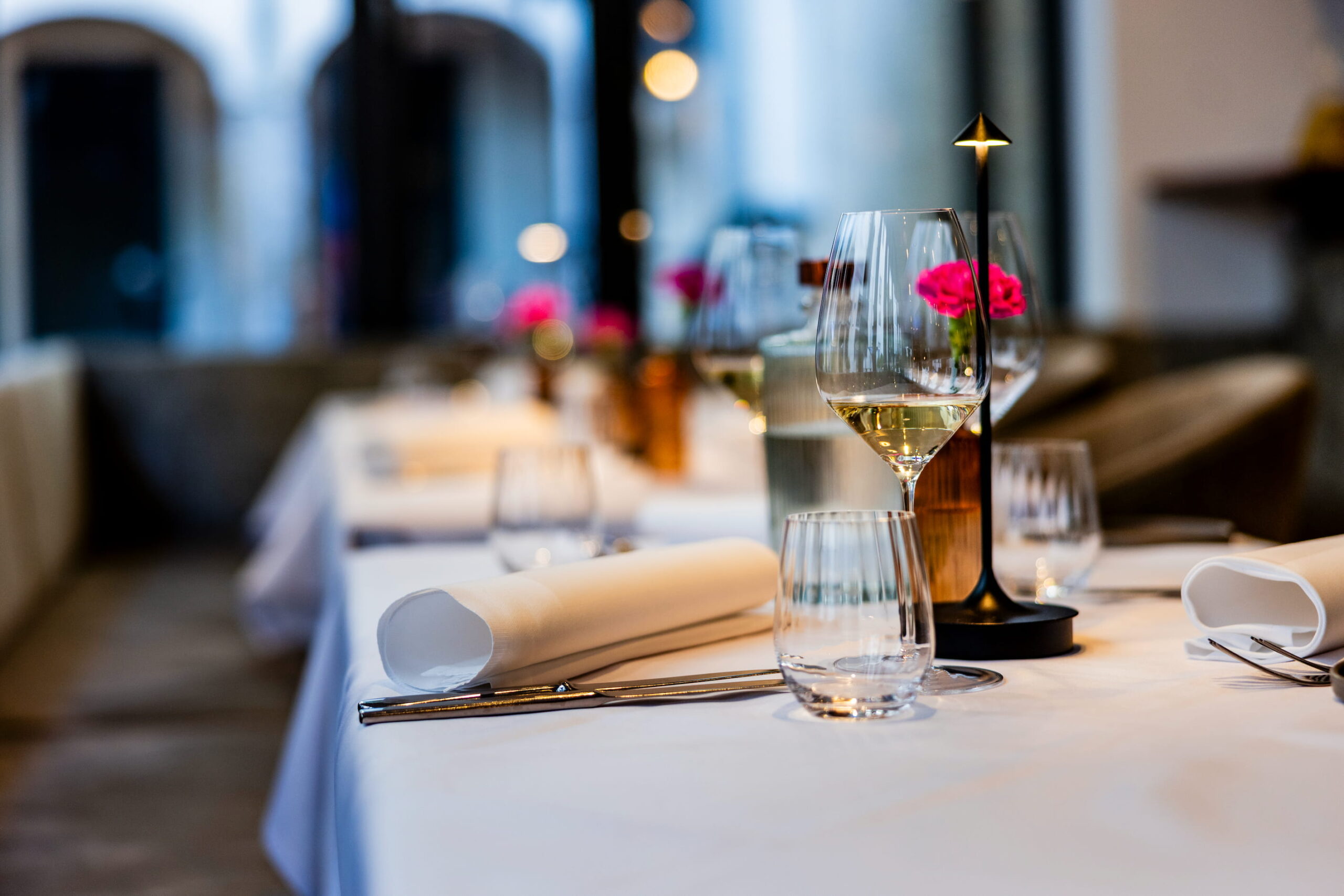 A set table with cloth napkins and lamps
